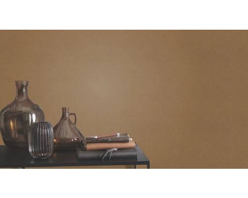 Vases décoratifs en verre et carnets sur une table devant un mur