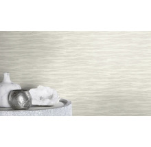 Dekorative Szene mit Vase, Windlicht und Kristall auf einem Tisch vor einer strukturierten Tapete.