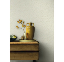 Szene mit einem beigen Wandhintergrund, einem beigen Samtsofa, einem Tablett, Vasen und einer Blume