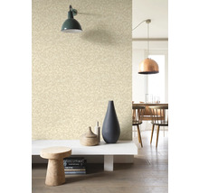 Wohnraum mit gemusterter Tapete, Wandleuchte und Dekorationselementen.