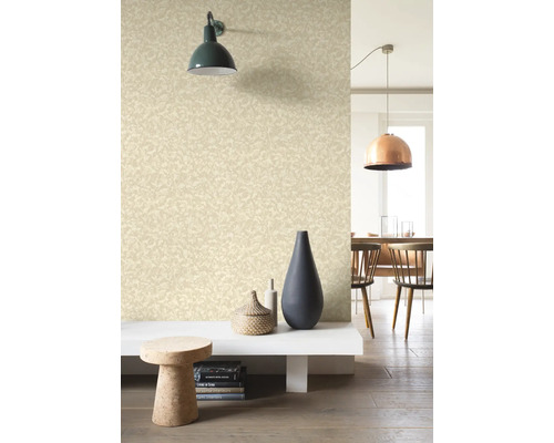 Wohnraum mit gemusterter Tapete, Wandleuchte und Dekorationselementen.