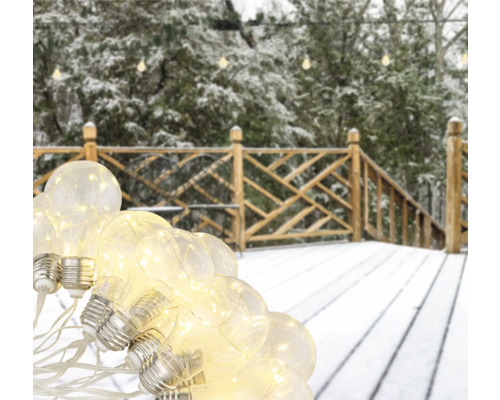 Lichterkette mit Glühbirnen auf einer verschneiten Terrasse.