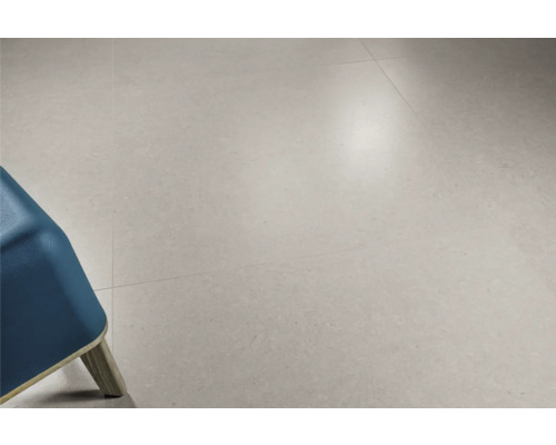 Fliesen auf dem Boden verlegt, mit Teil eines Stuhls im Bild.