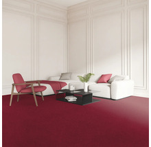Wohnzimmer mit rotem Teppich, weißem Sofa, Sessel und schwarzem Couchtisch