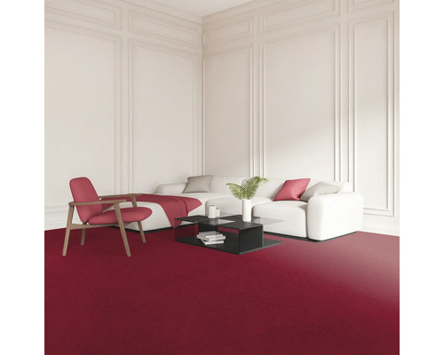 Wohnzimmer mit rotem Teppich, weißem Sofa, Sessel und schwarzem Couchtisch