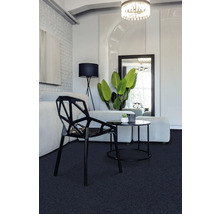 Salon avec moquette, chaise et table d''appoint.