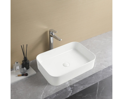 Vasque à poser rectangulaire en céramique avec robinet sur un plan de travail