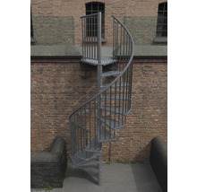 Metall Aussentreppe mit spiralförmigem Treppenlauf vor einer Backsteinmauer