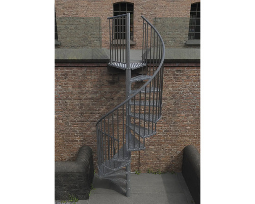 Metall Aussentreppe mit spiralförmigem Treppenlauf vor einer Backsteinmauer