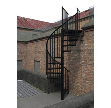 Wendeltreppe aus Metall vor einer Backsteinmauer