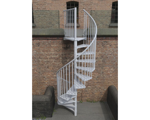 Freistehende Wendeltreppe aus Metall vor einer Ziegelwand