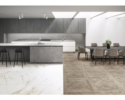 Heller Raum mit Küche, Essbereich und unterschiedlichen Bodenfliesen