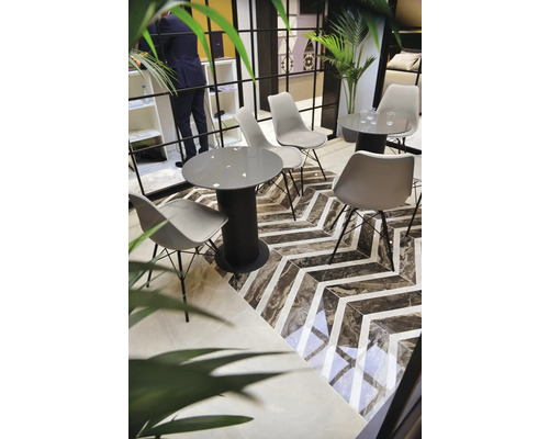 Groupe de sièges avec tables et chaises sur un sol à motif zigzag.