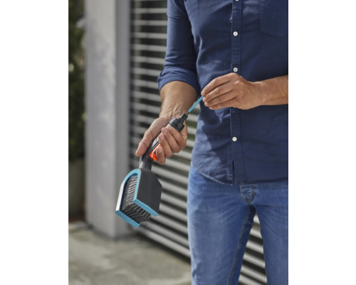 Eine Person befüllt eine Bürste mit einem Reinigungsstab für die Gartenbewässerung.