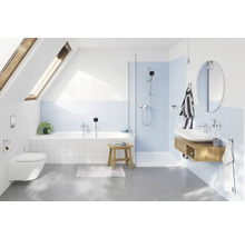 Salle de bains moderne avec baignoire, douche, lavabo et toilettes sous une fenêtre de toit.