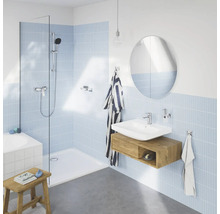 Salle de bain avec douche, lavabo, miroir et carreaux bleu clair