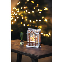 Maison en pain d''épices décorative avec neige et sapin de Noël en arrière-plan