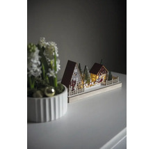 Dekorative Weihnachtsszene mit Häusern, Bäumen und Weihnachtsmannschlitten