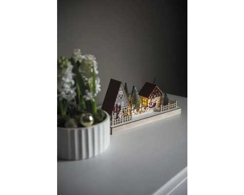 Dekorative Weihnachtsszene mit Häusern, Bäumen und Weihnachtsmannschlitten