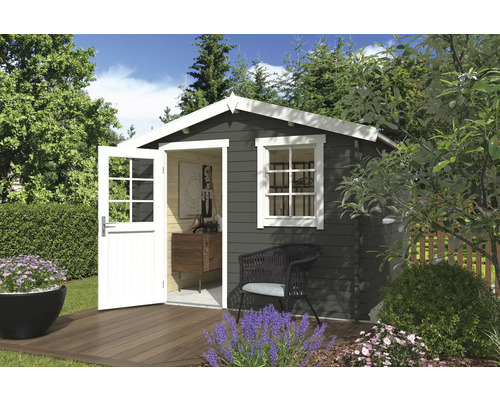 Abri de jardin en bois avec porte ouverte, fenêtre et mobilier de jardin sur une terrasse en bois