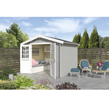Abri de jardin avec portes doubles ouvertes, coin salon et mobilier de jardin sur une terrasse
