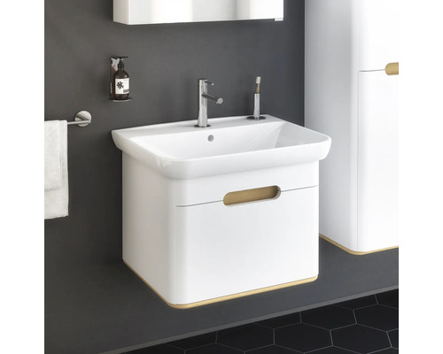 Weisser Waschtisch mit Armatur, Seifenspender und Handtuchhalter im Badezimmer.