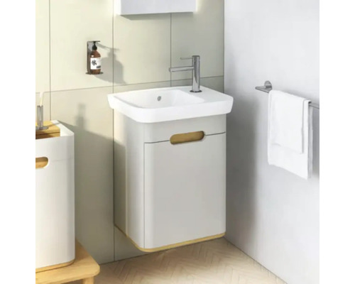 Badezimmer mit Waschbeckenunterschrank, Armatur, Handtuchhalter und Seifenspender