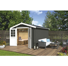 Abri de jardin avec portes doubles ouvertes, terrasse en bois et coin salon dans le jardin.