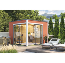 Abri de jardin moderne avec portes coulissantes et terrasse dans un jardin verdoyant.