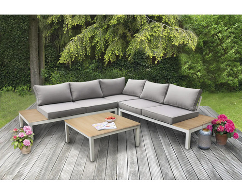 Gartenlounge-Set mit Tisch auf einer Holzterrasse im Garten.
