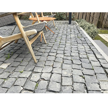 Aussenbereich mit Granitpflastersteinen, Sitzgelegenheiten und Gartenelementen.