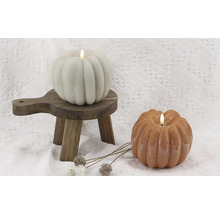 Deux bougies citrouille avec lumières LED sur un petit tabouret en bois
