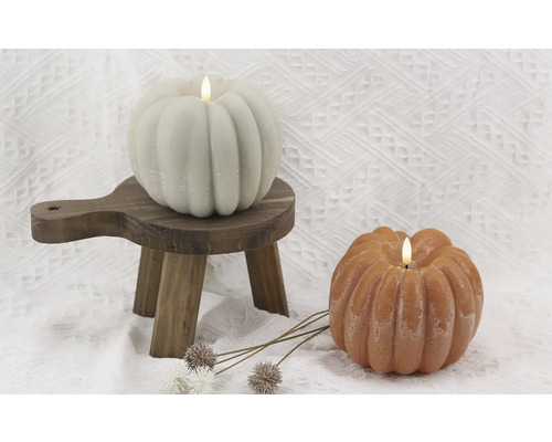 Deux bougies citrouille avec lumières LED sur un petit tabouret en bois