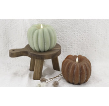 Bougies décoratives en forme de citrouille sur petit tabouret en bois et fond