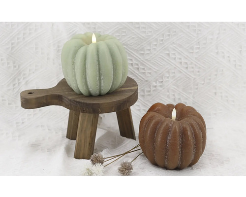 Bougies décoratives en forme de citrouille sur petit tabouret en bois et fond