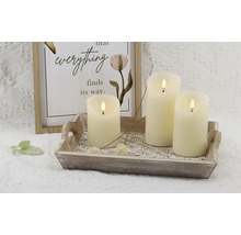 Bougies LED décoratives sur un plateau en bois avec une décoration murale encadrée