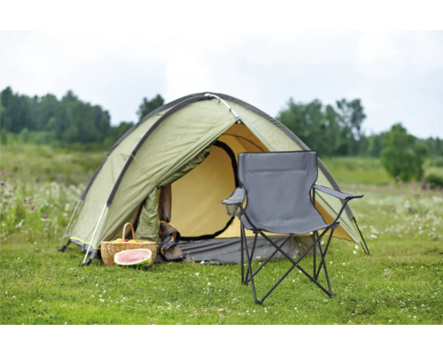 Scène de camping avec tente, panier de pique-nique et chaise de camping dans un champ