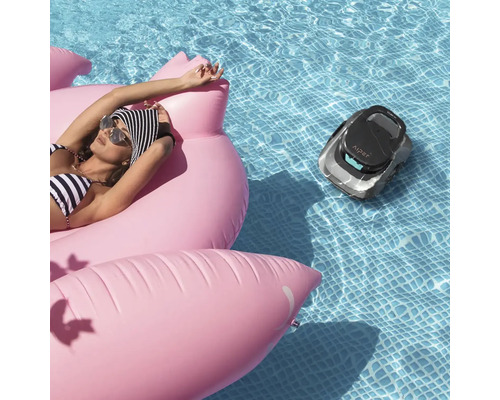 Scène avec une femme sur un flamant rose gonflable dans une piscine et un robot nettoyeur de piscine