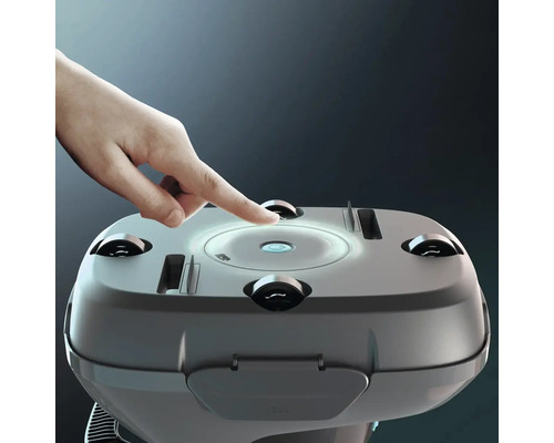 Un robot aspirateur est actionné avec le doigt.