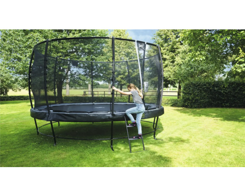 Trampoline avec filet de sécurité et échelle dans le jardin