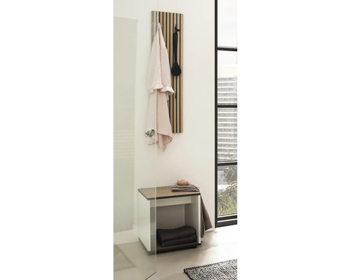 Salle de bain avec panneau de vestiaire, banc et serviettes pour une ambiance ordonnée.