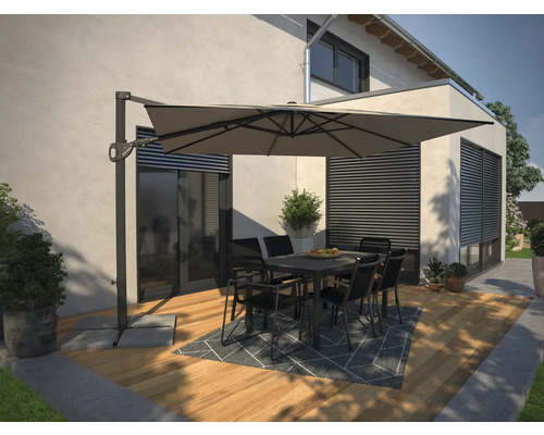 Terrasse avec parasol déporté, table et chaises devant une maison.
