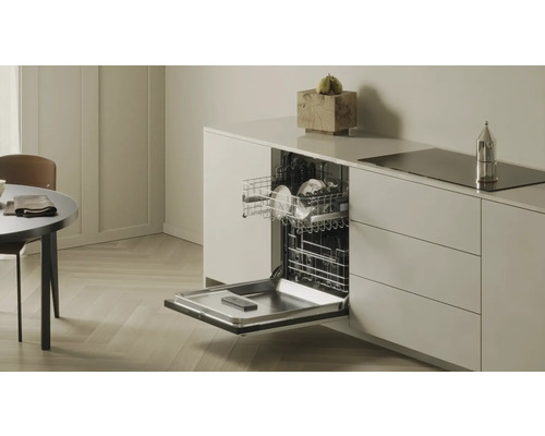 Offener Geschirrspüler mit Geschirr in moderner Küche.