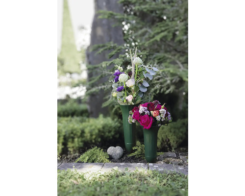 Zwei Blumengestecke in Vasen auf einem Grab