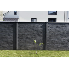 Mur en pierre avec poteaux en béton et herbe dans le jardin
