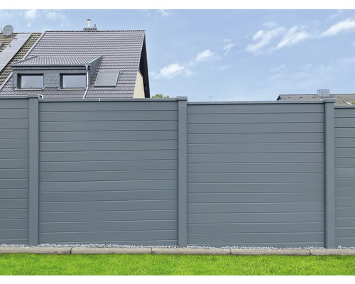 Clôture d''intimité grise dans un jardin devant une maison.