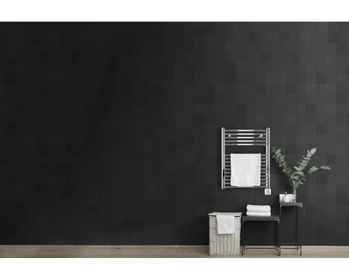 Salle de bains avec sèche-serviettes, panier à linge et table d''appoint devant un carrelage mural foncé