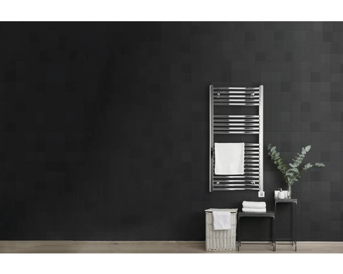 Salle de bains avec sèche-serviettes, panier à linge et décoration