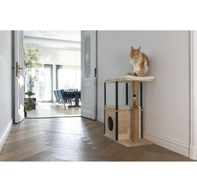 Chat sur un arbre à chat avec un espace de couchage et un poteau à griffer dans un salon lumineux