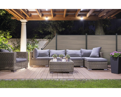 Gartenlounge-Set auf einer Holzterrasse unter einer Pergola mit Beleuchtung